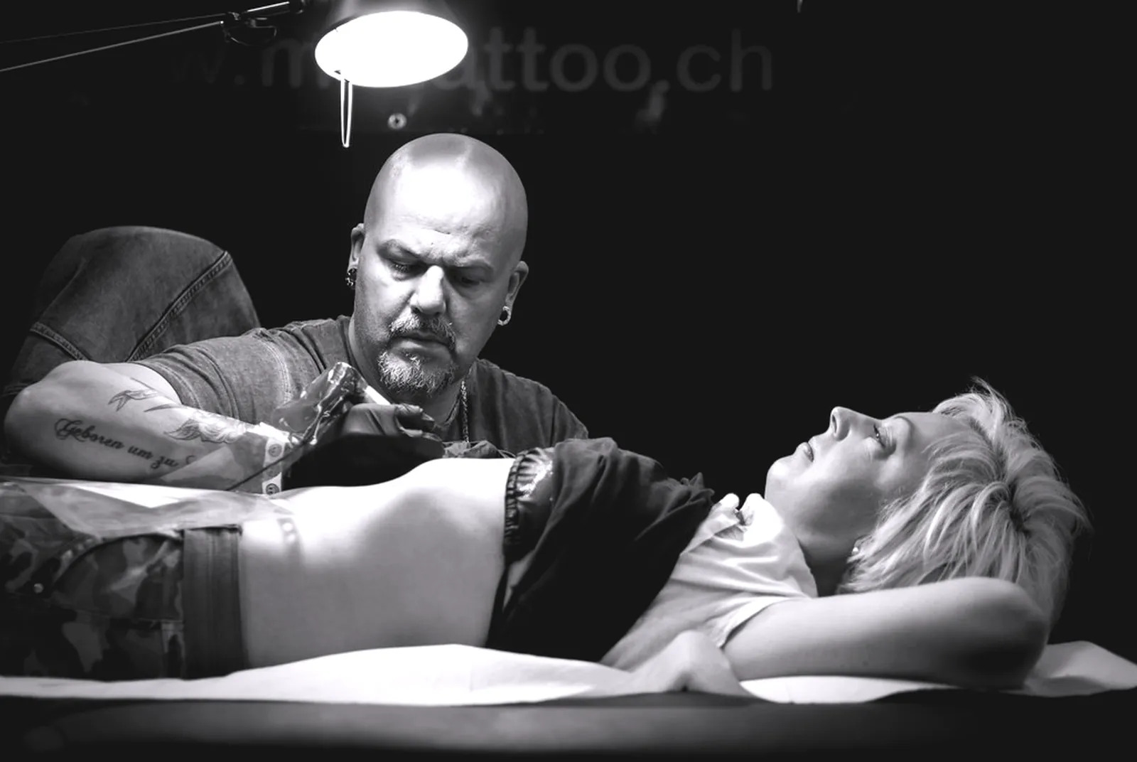 Tatuator lucrând atent în timpul unei ședințe